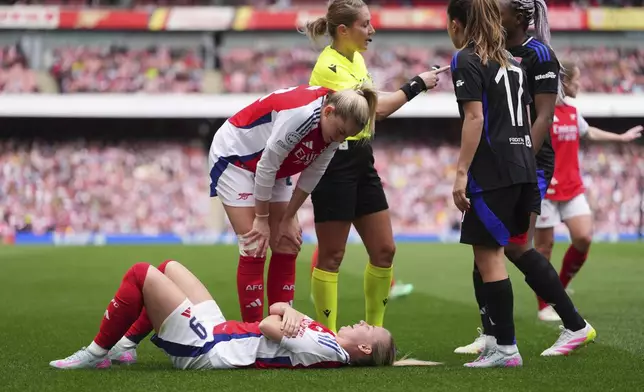 Arsenal's Alessia Russo checks on teammate Beth Mead, injured on the ground, during the women's Champions League semifinals, first leg, soccer match between Arsenal FC and Olympique Lyonnais at the Arsenal Stadium, in London, Saturday, April 19, 2025. (AP Photo/Kirsty Wigglesworth)