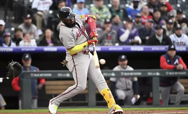 Atlanta Braves designated hitter Marcell Ozuna (20) hits into a ground out in the first inning of a baseball game against the Colorado Rockies, Tuesday, April 29, 2025, in Denver. (AP Photo/Geneva Heffernan)