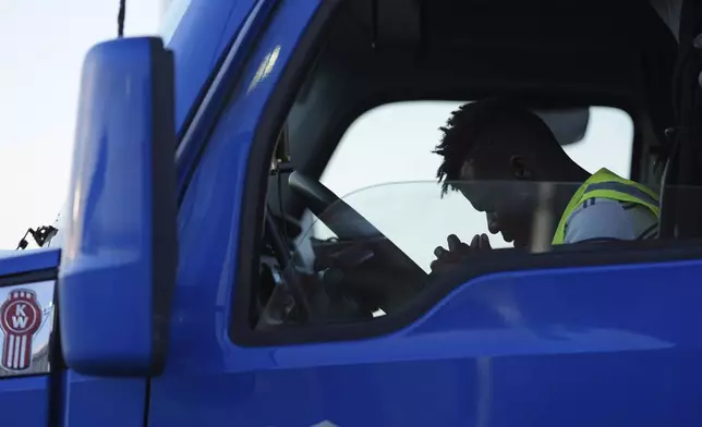 Haitian immigrant Kevenson Jean, a truck driver, prays before beginning a road trip, Tuesday, April 15, 2025, in Panhandle, Texas. (AP Photo/Eric Gay)