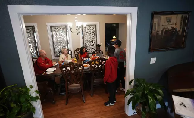 Haitian immigrants Sherlie Jean and husband Kevenson Jean, center, join friends and their sponsor for a meal, Monday, April 14, 2025, in Panhandle, Texas. (AP Photo/Eric Gay)