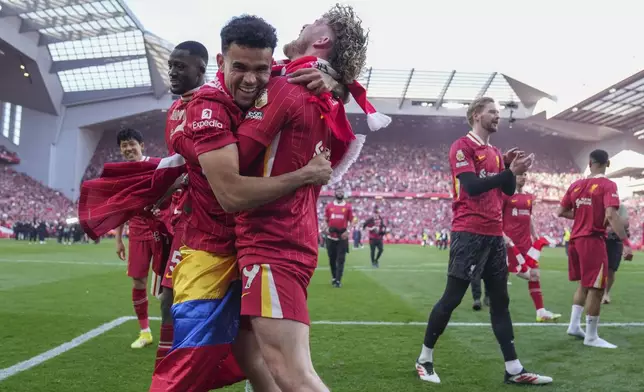 Liverpool's Luis Diaz, left, and Harvey Elliott celebrate after winning the English Premier League soccer match between Liverpool and Tottenham Hotspur and clinching the Premier League title at Anfield in Liverpool, England, Sunday, April 27, 2025. (AP Photo/Jon Super)