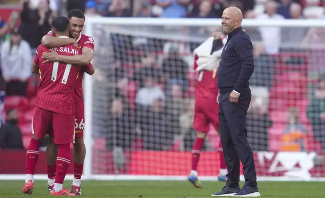 Liverpool's manager Arne Slot, Mohamed Salah and Trent Alexander-Arnold celebrate after winning the English Premier League soccer match between Liverpool and Tottenham Hotspur and clinching the Premier League title at Anfield in Liverpool, England, Sunday, April 27, 2025. (AP Photo/Jon Super)
