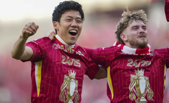 Liverpool's Wataru Endo celebrates with Liverpool's Harvey Elliott after winning the English Premier League soccer match between Liverpool and Tottenham Hotspur and clinching the Premier League title at Anfield in Liverpool, England, Sunday, April 27, 2025. (AP Photo/Jon Super)