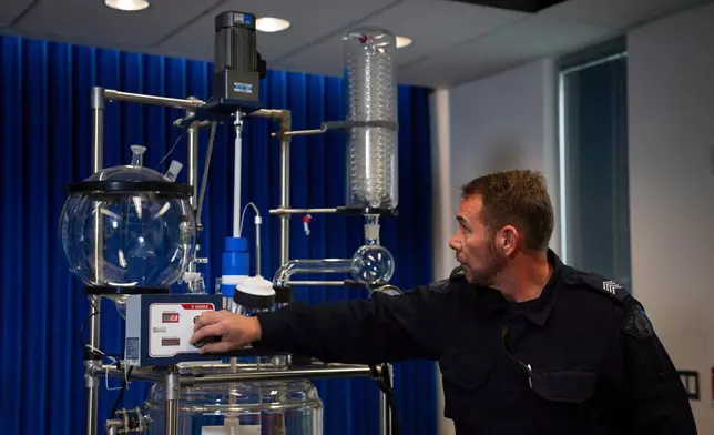 A police officer turns on a double wall reaction vessel during a Royal Canadian Mounted Police (RCMP) news conference announcing fentanyl production labs that have been dismantled around British Columbia, in Surrey, British Columbia,Thursday, April 10, 2025. (Ethan Cairns/The Canadian Press via AP)