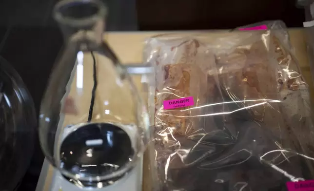 Lab equipment and fentanyl is pictured in evidence bags during a Royal Canadian Mounted Police (RCMP) news conference announcing production labs that have been dismantled around British Columbia, in Surrey, British Columbia, Thursday, April 10, 2025. (Ethan Cairns/The Canadian Press via AP)