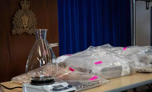 Lab equipment and fentanyl is pictured in evidence bags during a Royal Canadian Mounted Police (RCMP) news conference announcing production labs that have been dismantled around British Columbia, in Surrey, British Columbia, Thursday, April 10, 2025. (Ethan Cairns/The Canadian Press via AP)