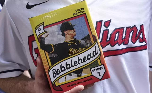 Cleveland Guardians fan Andy Lewis of Elyria, Ohio, holds his Pittsburgh Pirates' Paul Skenes bobblehead before a baseball game between the Pittsburgh Pirates and the Cleveland Guardians, with Pirates' Paul Skenes pitching, in Pittsburgh, Saturday, April 19, 2025. (AP Photo/Gene J. Puskar)