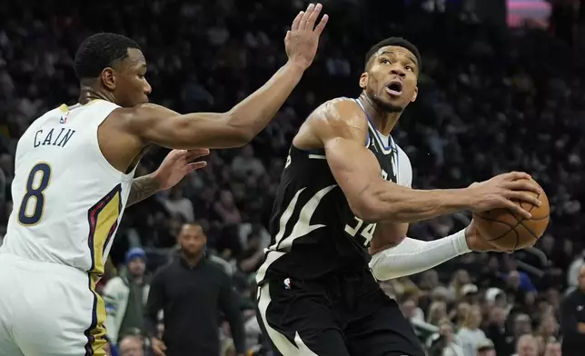 Milwaukee Bucks' Giannis Antetokounmpo, right, drives to the basket against New Orleans Pelicans' Jamal Cain (8) during the first half of an NBA basketball game Thursday, April 10, 2025, in Milwaukee. (AP Photo/Aaron Gash)