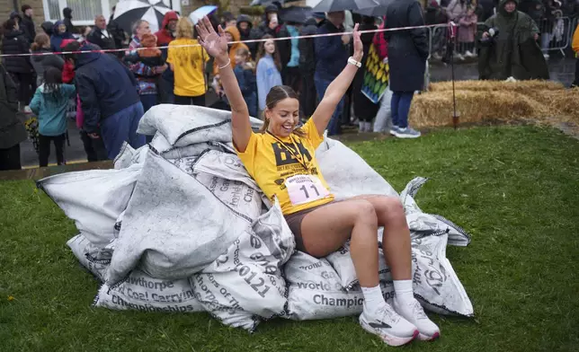 Winner Ferne Gardener reacts after racing with a 20kg sack of coal for over 1km during the World Coal Carrying Championships in Ossett, West Yorkshire, England, Monday, April 21, 2025. (AP Photo/Jon Super)