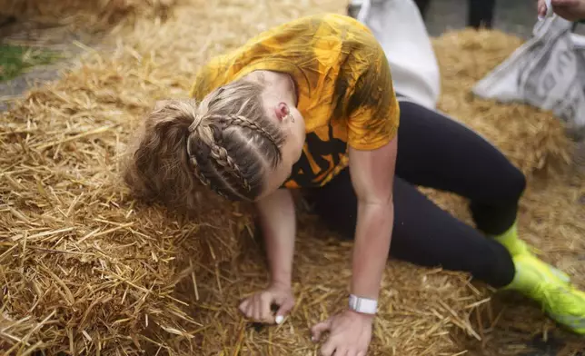 Jodie Ounsley, who plays Fury in the British TV show "Gladiators," reacts after finishing the women's open category race at the World Coal Carrying Championships in Ossett, West Yorkshire, England, Monday, April 21, 2025. (AP Photo/Jon Super)