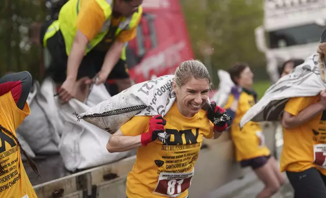 Verity Rees from Windermere, Florida, loads up a 20kg sack of coal on her way to winning the women's open category at the World Coal Carrying Championships in Ossett, West Yorkshire, England, Monday, April 21, 2025. (AP Photo/Jon Super)