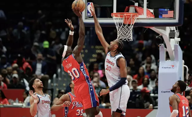 Philadelphia 76ers center Adem Bona (30) shoots the ball over Washington Wizards forward Alex Sarr (20) during the first half of an NBA basketball game in Washington, Wednesday, April 9, 2025. (AP Photo/Terrance Williams)