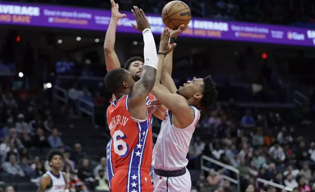 Washington Wizards guard Jaylen Martin is fouled by Philadelphia 76ers guard Lonnie Walker IV while attempting a shot during the first half of an NBA basketball game in Washington, Wednesday, April 9, 2025. (AP Photo/Terrance Williams)