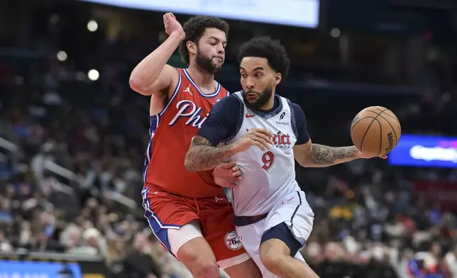 Washington Wizards forward Justin Champagnie (9) drives to the basket as Philadelphia 76ers forward Alex Reese defends during the first half of an NBA basketball game in Washington, Wednesday, April 9, 2025. (AP Photo/Terrance Williams)
