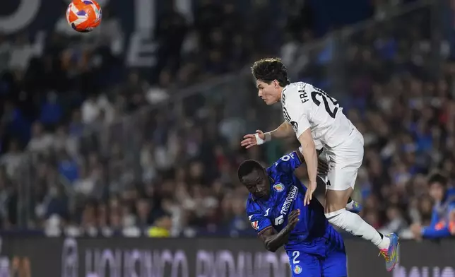 Getafe's Djene Dakonam, bottom, and Real Madrid's Fran Garcia challenge for the ball during a Spanish La Liga soccer match between Getafe and Real Madrid at the Coliseum Alfonso Perez stadium in Getafe, Spain, Wednesday, April 23, 2025. (AP Photo/Manu Fernandez)