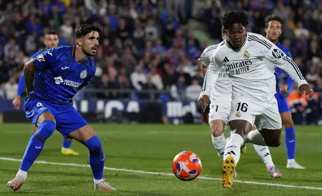 Getafe's Juan Berrocal, left, and Real Madrid's Endrick challenge for the ball during a Spanish La Liga soccer match between Getafe and Real Madrid at the Coliseum Alfonso Perez stadium in Getafe, Spain, Wednesday, April 23, 2025. (AP Photo/Manu Fernandez)