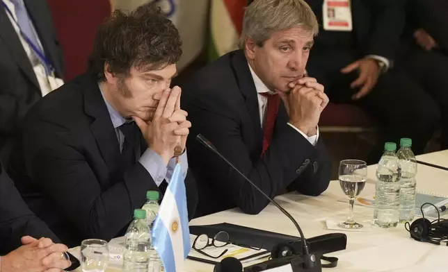 FILE - Argentina's President Javier Milei, left, and Economy Minister Luis Caputo attend the Mercosur Summit in Montevideo, Uruguay, Dec. 6, 2024. (AP Photo/Matilde Campodonico, File)