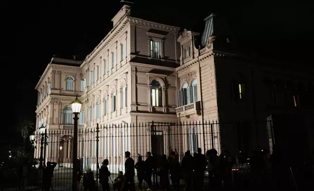 Journalists wait outside Government House where Economy Minister Luis Caputo is holding a conference, in Buenos Aires, Argentina, Friday, April 11, 2025. (AP Photo/Natacha Pisarenko)