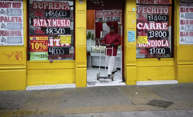 A worker pushes a dolly at a butcher in Buenos Aires, Argentina, Monday, March 31, 2025. (AP Photo/Natacha Pisarenko)