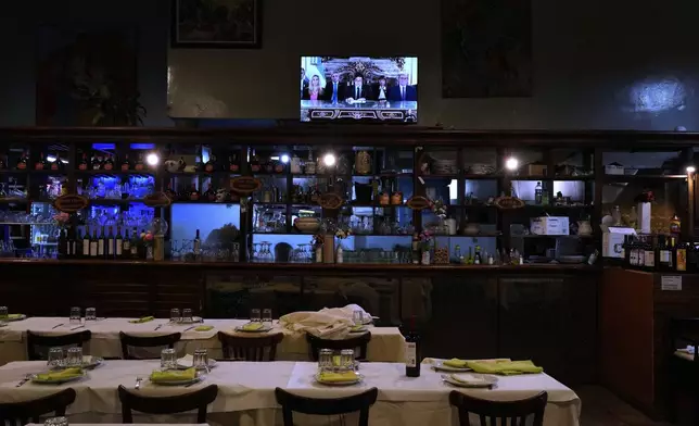 A television airs a national message by President Javier Milei, accompanied by members of his Cabinet, at a restaurant in Buenos Aires, Argentina, Friday, April 11, 2025. (AP Photo/Natacha Pisarenko)