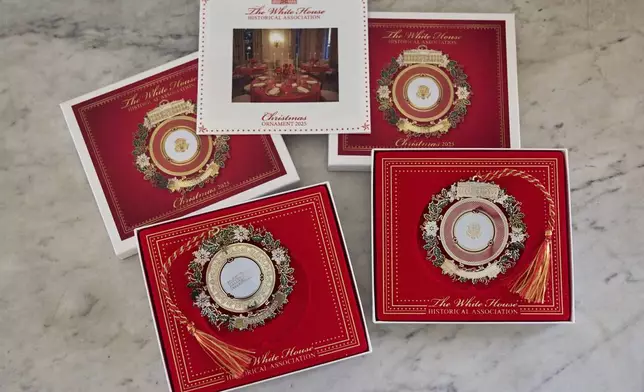 The front and back of the 2025 White House Christmas ornament is pictured with the box and information packet, Thursday, April 10, 2025, at the association in Washington. (AP Photo/Jacquelyn Martin)