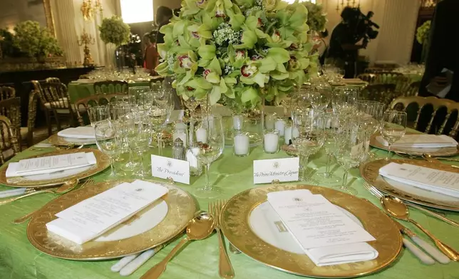 FILE - Gold china commissioned under the President Bill Clinton administration to commemorate the 200th anniversary of the White House, is seen with place settings for President George W. Bush, left, and Japanese Prime Minister Junichiro Koizumi, right, before official dinner in the State Dining Room of the White House, June 29, 2006, in Washington. (AP Photo/Pablo Martinez Monsivais, File)