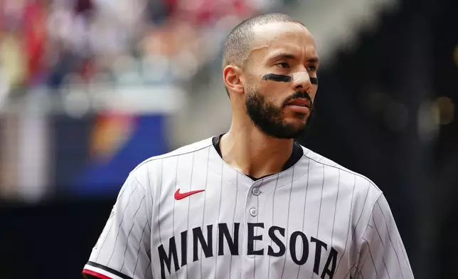 Minnesota Twins shortstop Carlos Correa (4) walks back to the dugout for his glove between innings during a baseball game against the Minnesota Twins, Saturday, April 20, 2025, in Atlanta. (AP Photo/John David Mercer)