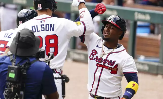 Atlanta Braves' Matt Olson (28) celebrates his two-run home run against the Minnesota Twins with teammate Ozzie Albies (1) during the first inning of a baseball game Saturday, April 20, 2025, in Atlanta. (AP Photo/John David Mercer)
