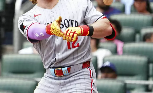 Minnesota Twins' Harrison Bader (12) tosses his bat heading to first base during the third inning of a baseball game against the Atlanta Braves, Saturday, April 20, 2025, in Atlanta. (AP Photo/John David Mercer)