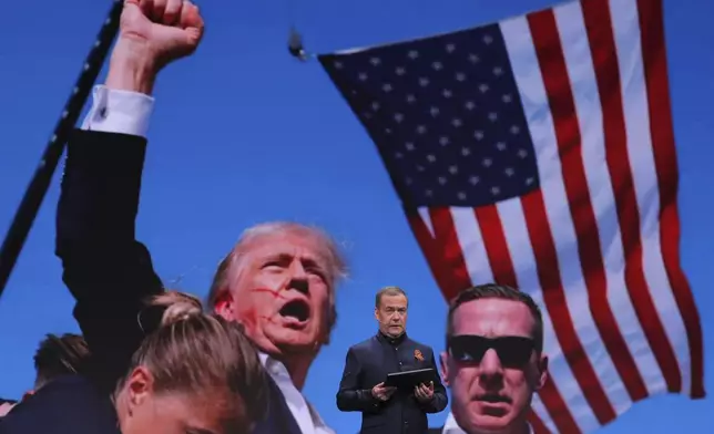 Russian Security Council Deputy Chairman and the head of the United Russia party Dmitry Medvedev addresses a session titled "Our dangerous world: who is to blame and what to do?" of the Educational marathon at the Victory Museum on Poklonnaya Gora in Moscow, Russia, Tuesday, April 29, 2025, with a photo of Donald Trump during an assassination attempt on the screen in the background. (Ekaterina Shtukina, Sputnik, Pool Photo via AP)