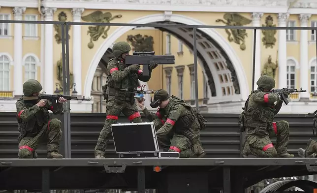 Servicemen ride on a moving platform during a rehearsal for the Victory Day military parade, which will take place at Dvortsovaya (Palace) Square on May 9 to celebrate 80 years after the victory in World War II, in St. Petersburg, Russia, Tuesday, April 22, 2025. (AP Photo/Dmitri Lovetsky)