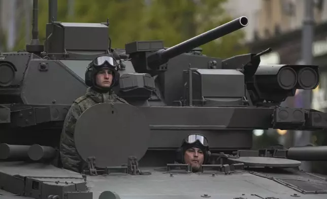 Russian soldiers sit at a tank driving along Tverskaya street to attend a rehearsal for the Victory Day military parade in Moscow, Russia, on Tuesday, April 29, 2025. (AP Photo/Pavel Bednyakov)
