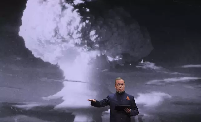 Russian Security Council Deputy Chairman and the head of the United Russia party Dmitry Medvedev addresses a session titled "Our dangerous world: who is to blame and what to do?" of the Educational marathon at the Victory Museum on Poklonnaya Gora in Moscow, Russia, Tuesday, April 29, 2025, with an image of nuclear explosion on the screen in the background. (Ekaterina Shtukina, Sputnik, Pool Photo via AP)