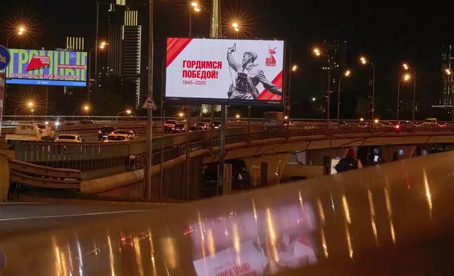 Cars pass an electronic billboard showing the photograph Kombat (a battalion commander) by Soviet photographer Max Alpert depicting a Soviet officer armed with a TT pistol during World War II, ahead of celebrations of the 80th anniversary of the Soviet Union's victory over Nazi Germany during World War II, in Moscow, Russia, Monday, April 28, 2025. (AP Photo/Alexander Zemlianichenko)