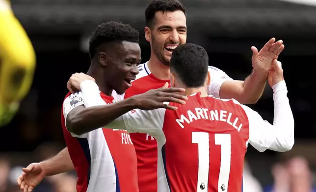 Arsenal's Gabriel Martinelli, right, celebrates scoring their side's second goal of the game during the English Premier League soccer match between Ipswich Town and Arsenal at Portman Road, Ipswich, England, Sunday, April 20, 2025. (John Walton/PA via AP)