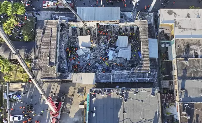 Rescue workers search for survivors at the Jet Set nightclub after its roof collapsed during a merengue concert in Santo Domingo, Dominican Republic, Tuesday, April 8, 2025.(Noticias SIN via AP)