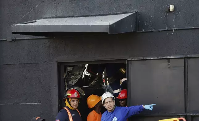 Rescue workers search for survivors at the Jet Set nightclub after its roof collapsed during a merengue concert in Santo Domingo, Dominican Republic, Tuesday, April 8, 2025. (AP Photo/Eddy Vittini)