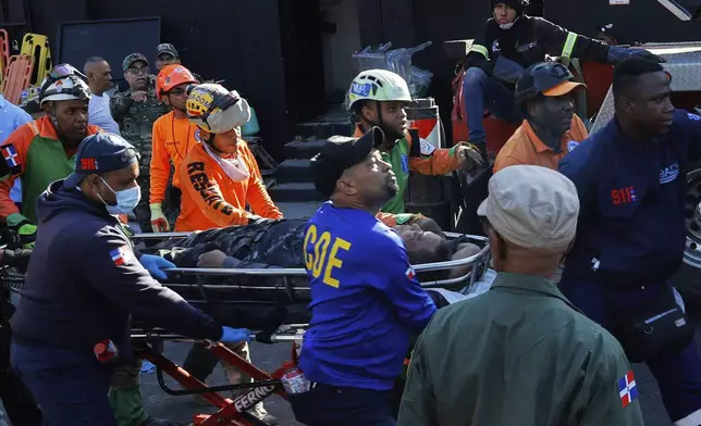 Rescue workers carry a person pulled from the wreckage of the nightclub after its roof collapsed during a merengue concert in Santo Domingo, Dominican Republic, Tuesday, April 8, 2025. (AP Photo/Eddy Vittini)