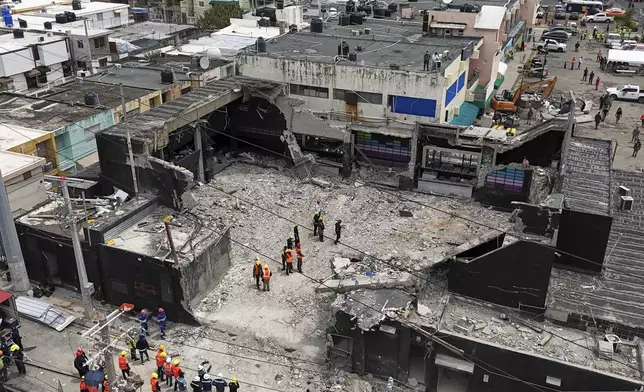 Rescue workers stand at the Jet Set nightclub after its roof collapsed, killing more than 200 people in Santo Domingo, Dominican Republic, Thursday, April 10, 2025. (AP Photo/Matias Delacroix)