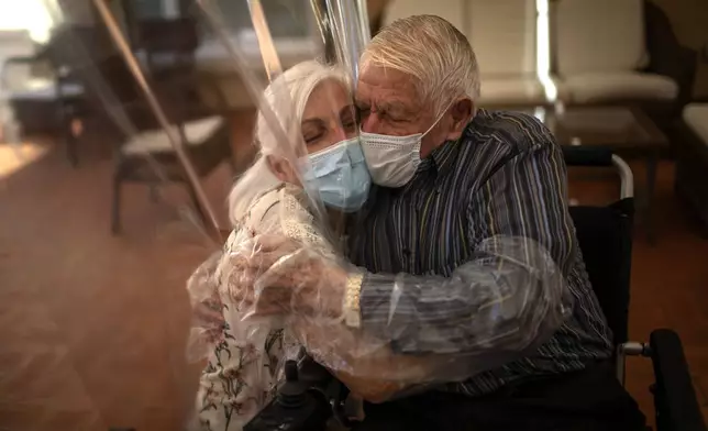 FILE - Dolores Reyes Fernández, 61, hugs her father, José Reyes Lozano, 87, for the first time in nearly four months as visits resume at the nursing home in Barcelona, Spain, Monday, June 22, 2020. (AP Photo/Emilio Morenatti, File)