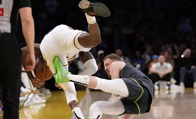 Los Angeles Lakers forward Jarred Vanderbilt, left, and Minnesota Timberwolves guard Donte DiVincenzo collide during the second half in Game 1 of an NBA first-round playoff series Saturday, April 19, 2025, in Los Angeles. (AP Photo/Mark J. Terrill)