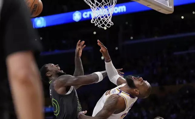 Los Angeles Lakers forward LeBron James, right, reacts after being hit in the face by Minnesota Timberwolves forward Julius Randle as Randle was shooting during the second half in Game 1 of an NBA first-round playoff series Saturday, April 19, 2025, in Los Angeles. (AP Photo/Mark J. Terrill)