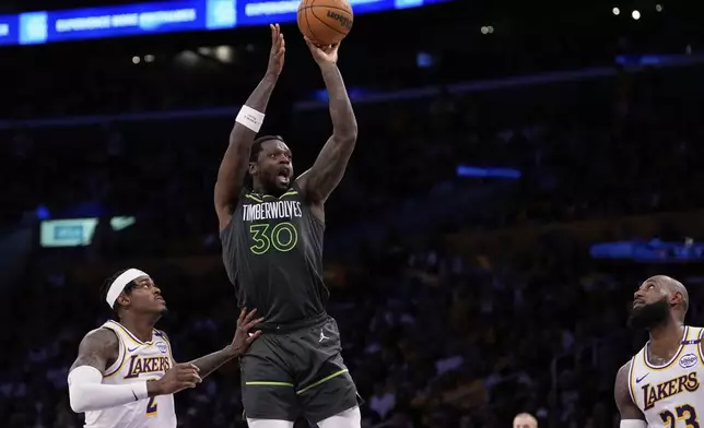 Minnesota Timberwolves forward Julius Randle, center, shoots as Los Angeles Lakers forward Jarred Vanderbilt, left, and forward LeBron James defend during the second half in Game 1 of an NBA first-round playoff series Saturday, April 19, 2025, in Los Angeles. (AP Photo/Mark J. Terrill)