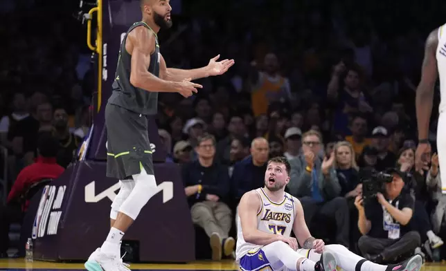Minnesota Timberwolves center Rudy Gobert, left, gestures as Los Angeles Lakers guard Luka Doncic talks to him after Gobert tripped over Doncic during the first half in Game 1 of an NBA first-round playoff series Saturday, April 19, 2025, in Los Angeles. (AP Photo/Mark J. Terrill)