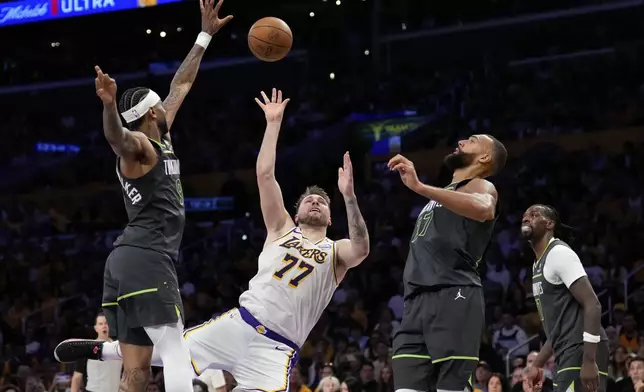 Los Angeles Lakers guard Luka Doncic (77) shoots as Minnesota Timberwolves guard Nickeil Alexander-Walker (9), center Rudy Gobert and center Naz Reid defend during the first half in Game 1 of an NBA first-round playoff series Saturday, April 19, 2025, in Los Angeles. (AP Photo/Mark J. Terrill)