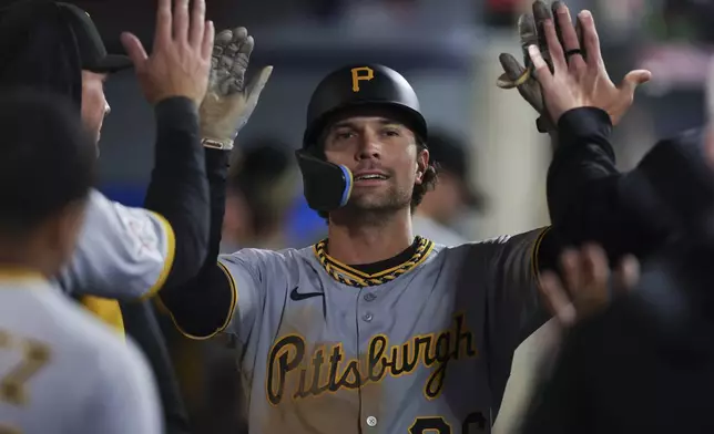Pittsburgh Pirates' Adam Frazier celebrates with teammates in the dugout after scoring on an RBI double by Isiah Kiner-Falefa during the ninth inning of a baseball game against the Los Angeles Angels in Anaheim, Calif., Tuesday, April 22, 2025. (AP Photo/Jessie Alcheh)