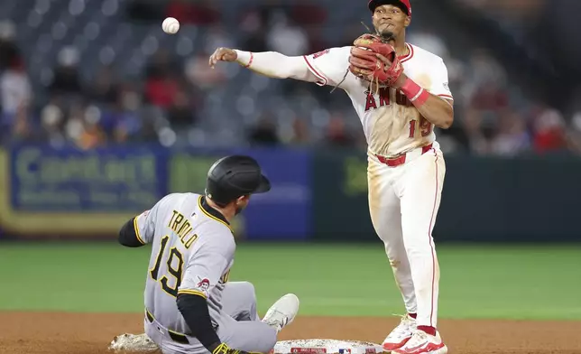 Los Angeles Angels second baseman Kyren Paris, right, throws to first base to complete the double play as Pittsburgh Pirates' Jared Triolo slides into second base during the eighth inning of a baseball game in Anaheim, Calif., Tuesday, April 22, 2025. (AP Photo/Jessie Alcheh)