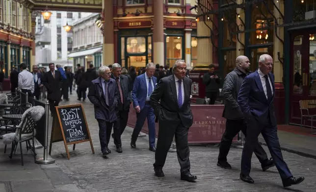 People walk in Leadenhall Market at lunch time, in the financial district, known as The City in London, Wednesday, April 9, 2025. (AP Photo/Alberto Pezzali)