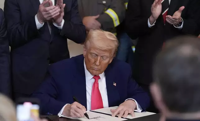 President Donald Trump signs an executive order during an event in the East Room of the White House, Tuesday, April 8, 2025, in Washington. (AP Photo/Alex Brandon)