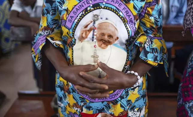 A parishioner wears clothes with a portrait of the late Pope Francis during a mass at the Catholic Church in Goma, Democratic Republic of Congo, Saturday, April 26, 2025. (AP Photo/Moses Sawasawa)